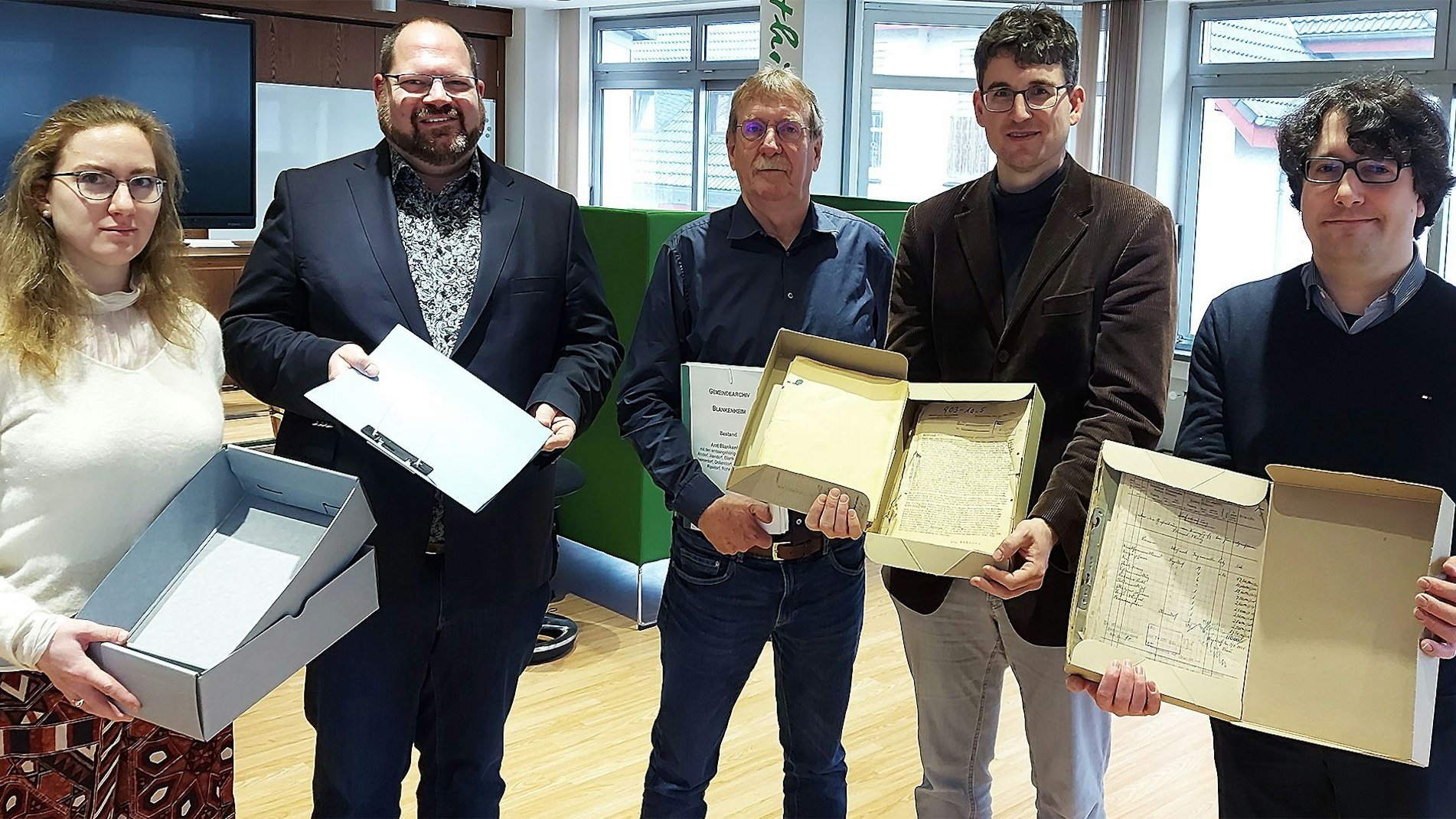 Eine Frau und vier Männer halten Schachteln mit Material aus dem Blankenheimer Gemeindearchiv in den Händen.