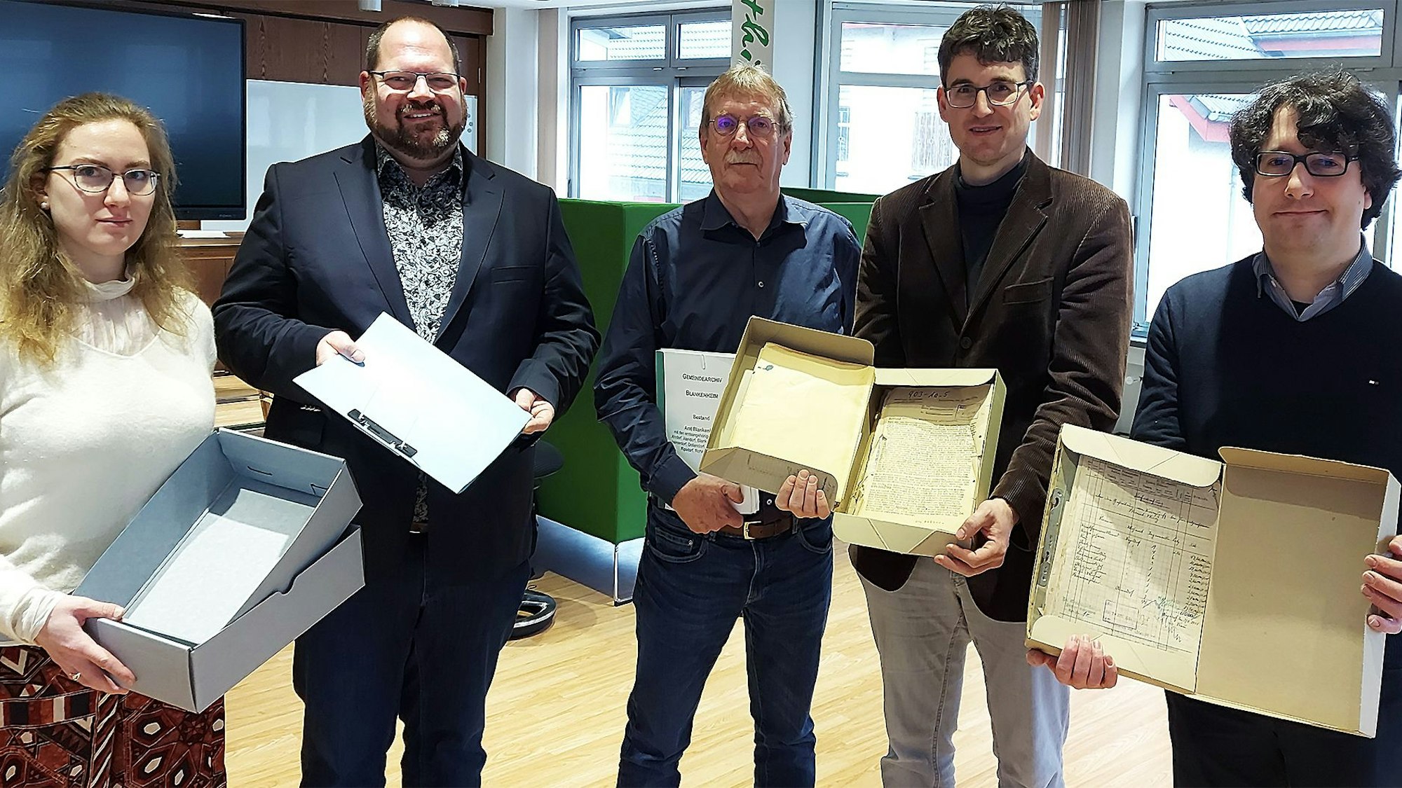 Eine Frau und vier Männer halten Schachteln mit Material aus dem Blankenheimer Gemeindearchiv in den Händen.