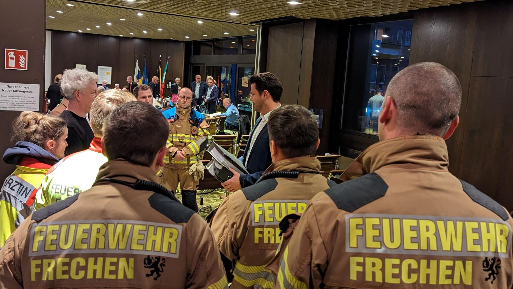 Auf dem Bild sind Feuerwehrleute zu sehen, die Protestschreiben übergeben.