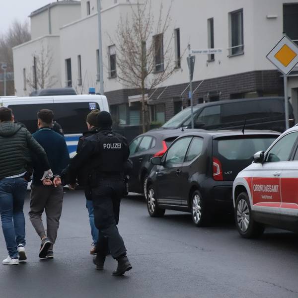 Die Polizei führt bei der Razzia in Hennef einen Verdächtigen ab.