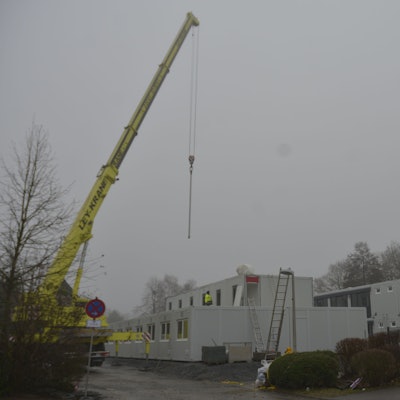 Container für die Unterbringung von Geflüchteten werden auf dem Parkplatz neben der kleinen Turnhalle an der Brionner Straße aufgebaut.
