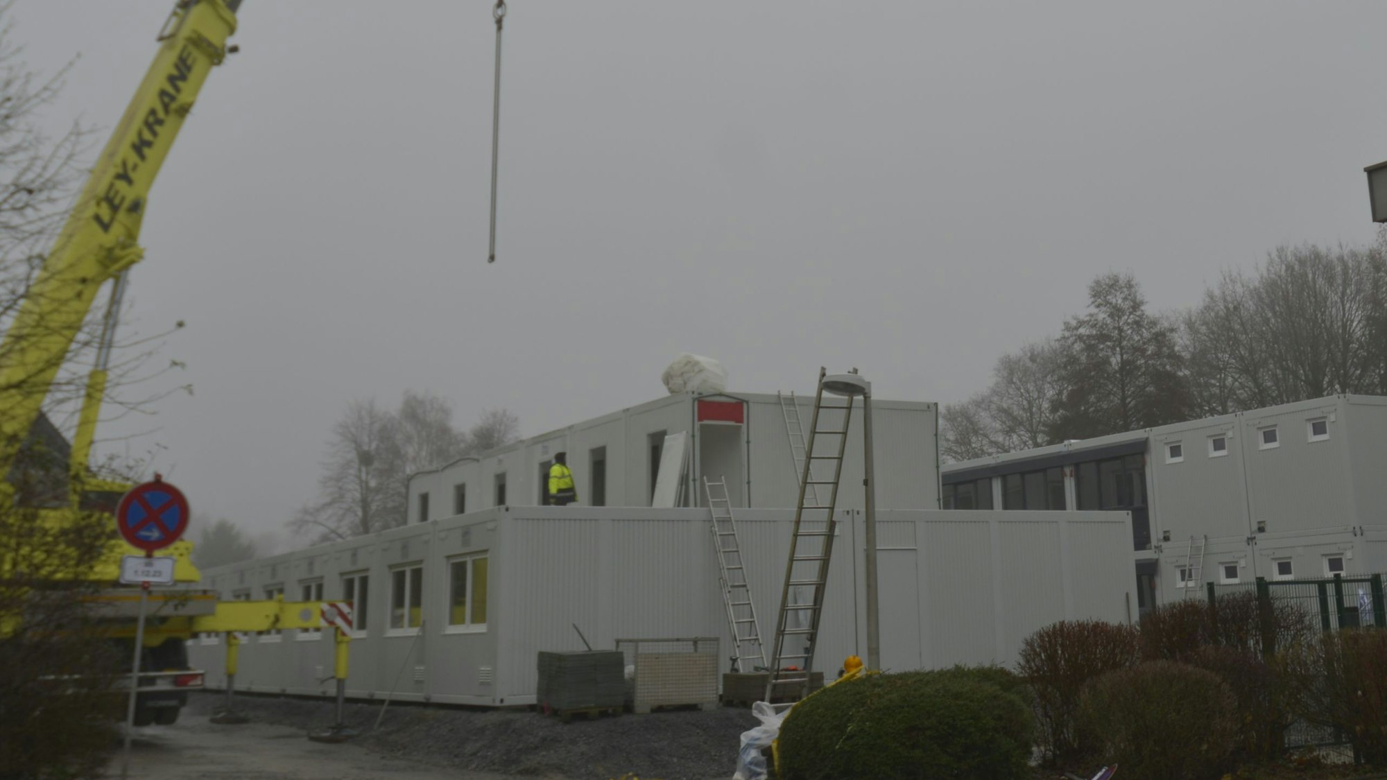 Container für die Unterbringung von Geflüchteten werden auf dem Parkplatz neben der kleinen Turnhalle an der Brionner Straße aufgebaut.