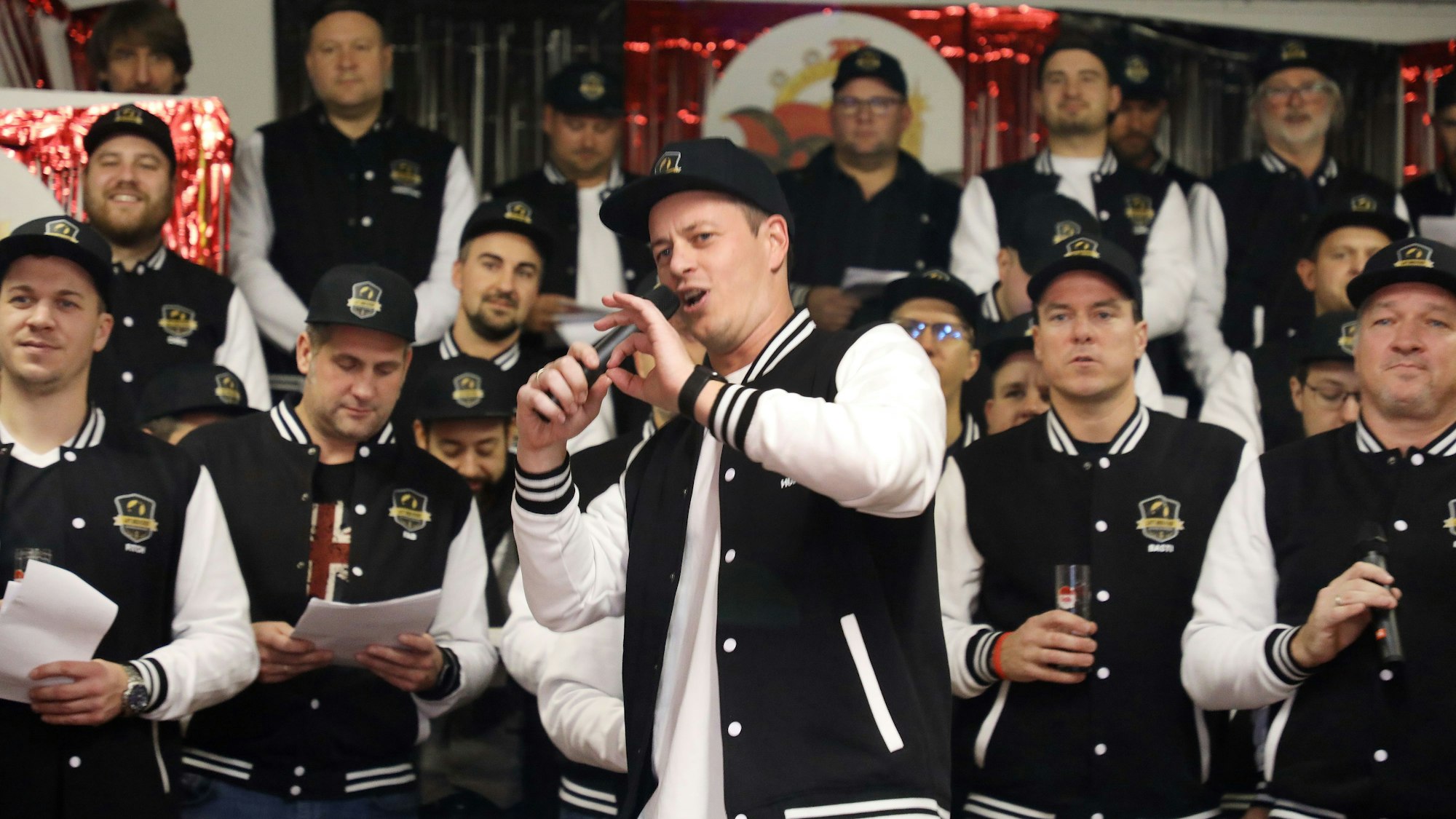 Ein Mann mit Mikro singt ein Solo vor dem Männerchor „Laut aber schief“.