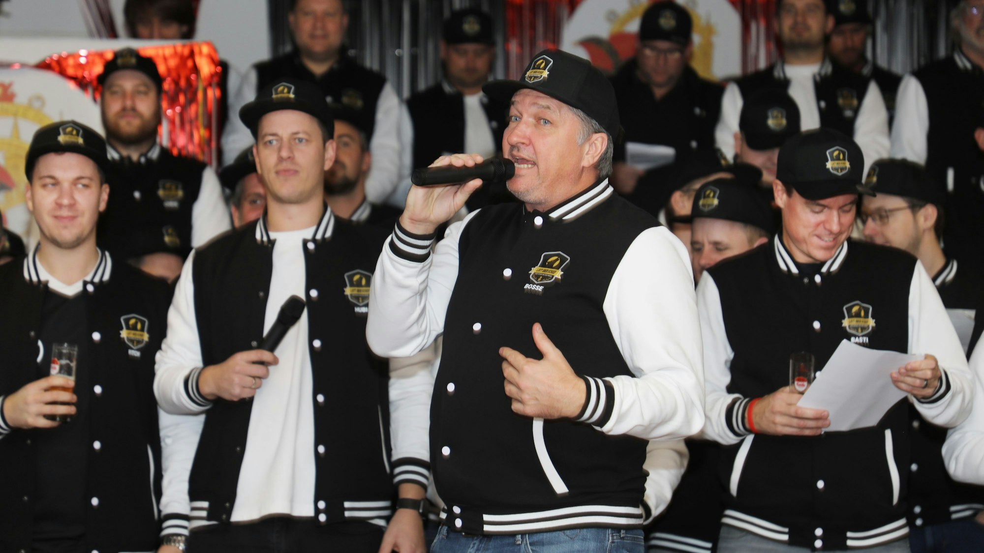 Thorsten Traugott sing mit Mikro ein Solo vor dem Chor „Laut aber schief“ in Marialinden.