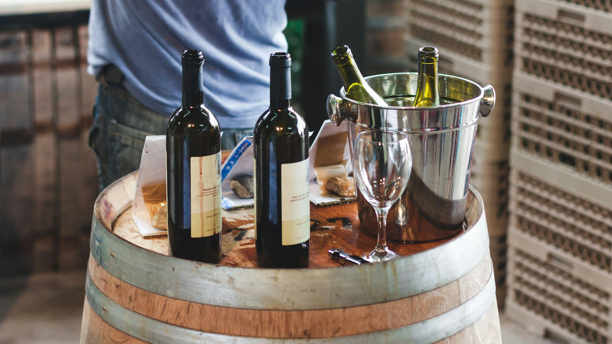 Weinflaschen auf einem Weinfass.