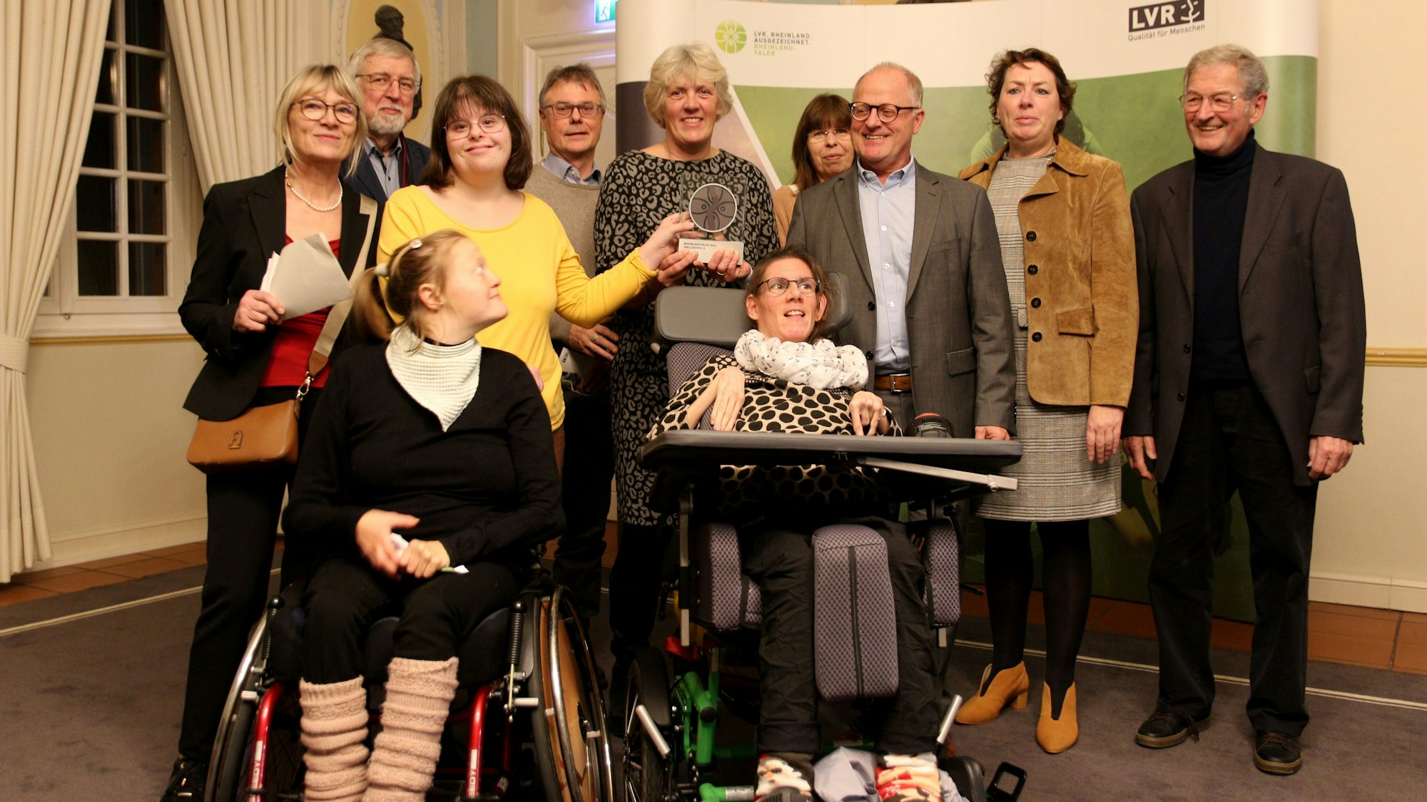 Eine Gruppe von Menschen, zwei davon im Rollstuhl, in der Abtei Brauweiler.