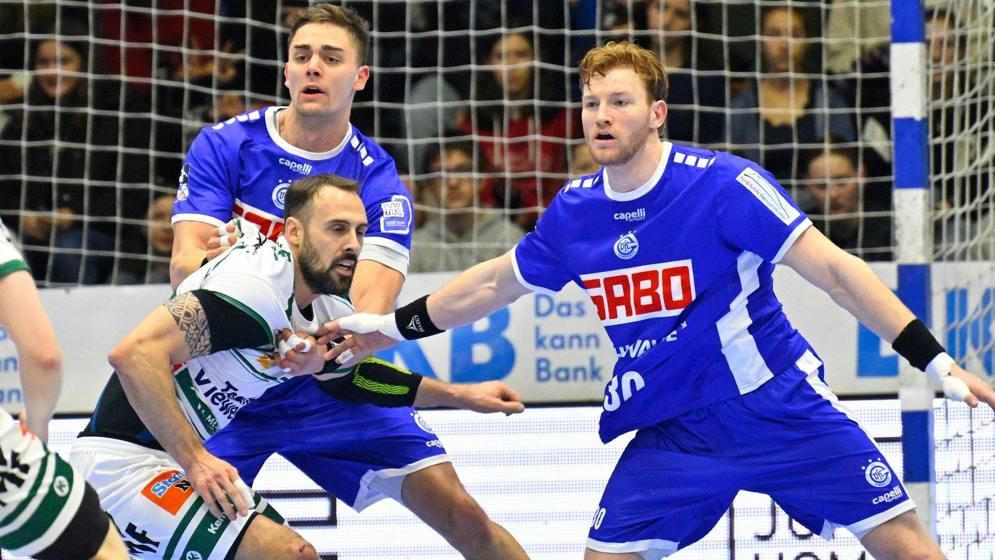 Stepan Zeman und Tom Kiesler stehen im Mittelblock und wehren Tim Kneule ab.
