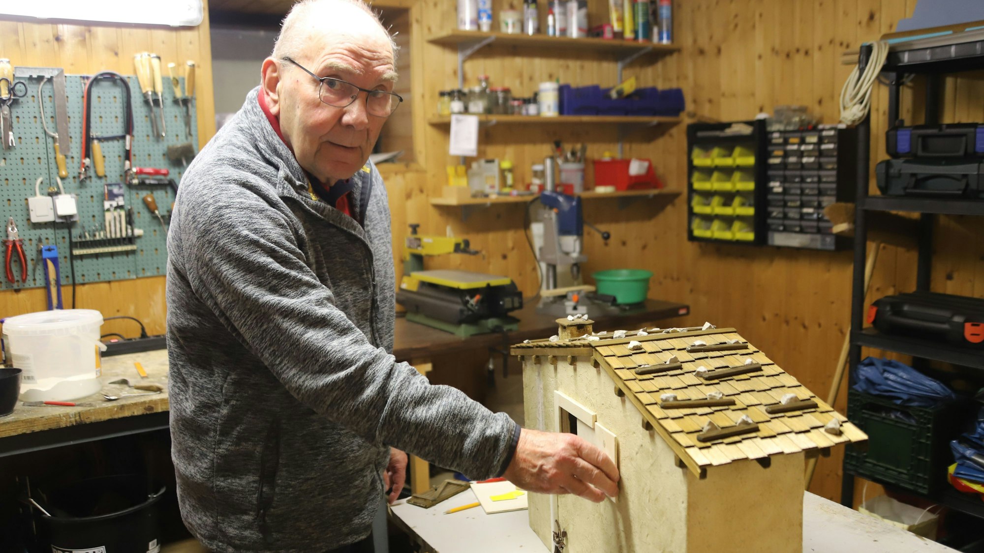 Werner Lehrmann bastelt heute noch an seinen Häusern, hier hat er eine Revisionsklappe eingesetzt, um ans Innere zu gelangen.