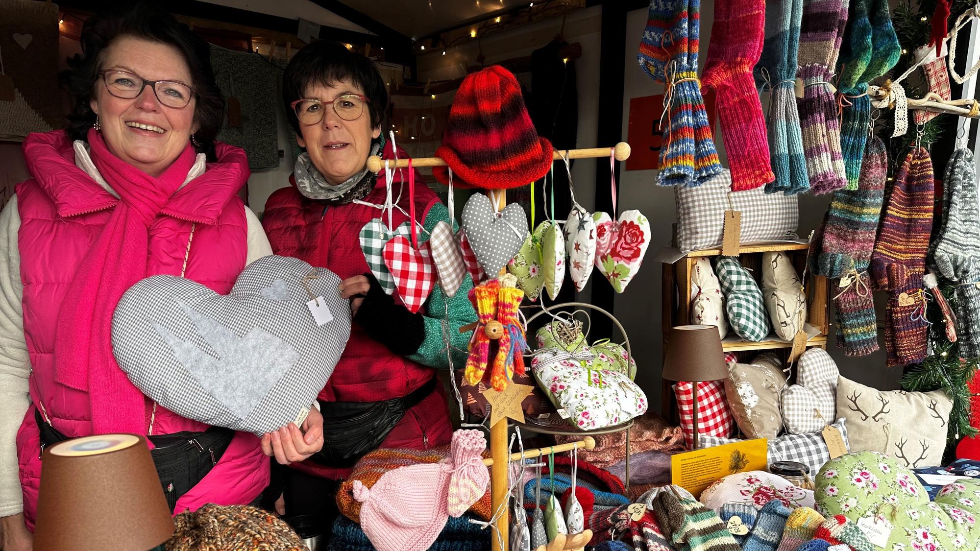 Zwei Frauen hinter selbst gestrickten Socken und Mützen.