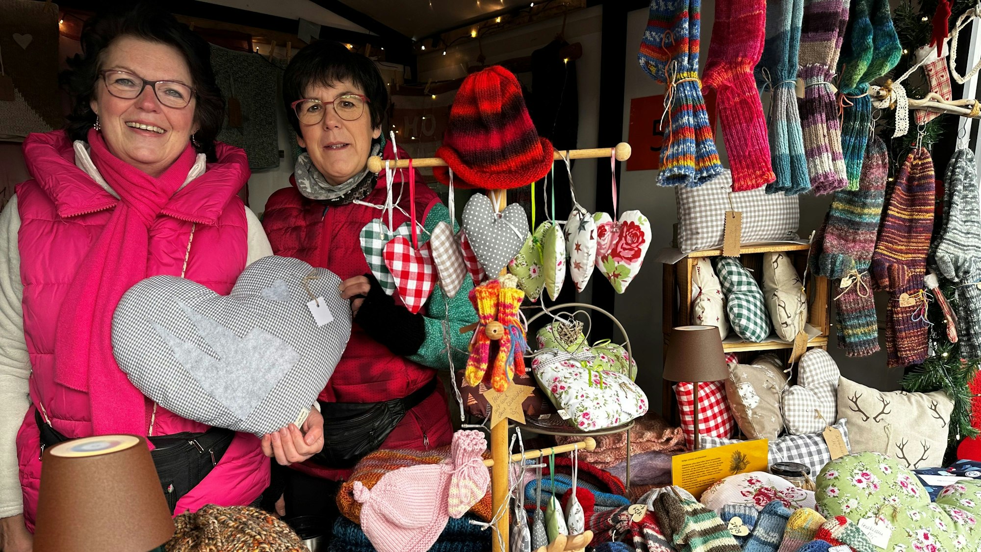 Zwei Frauen hinter selbst gestrickten Socken und Mützen.