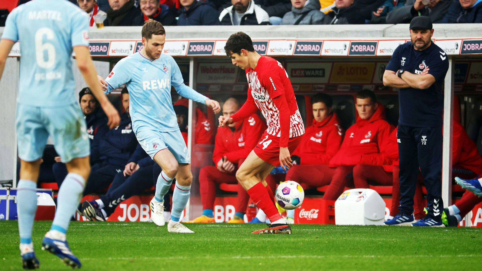 Freiburgs Merlin Röhl (2.v.r) und Kölns Benno Schmitz (2.v.l) kämpfen unter den Augen von Kölns Trainer Steffen Baumgart (r) um den Ball.