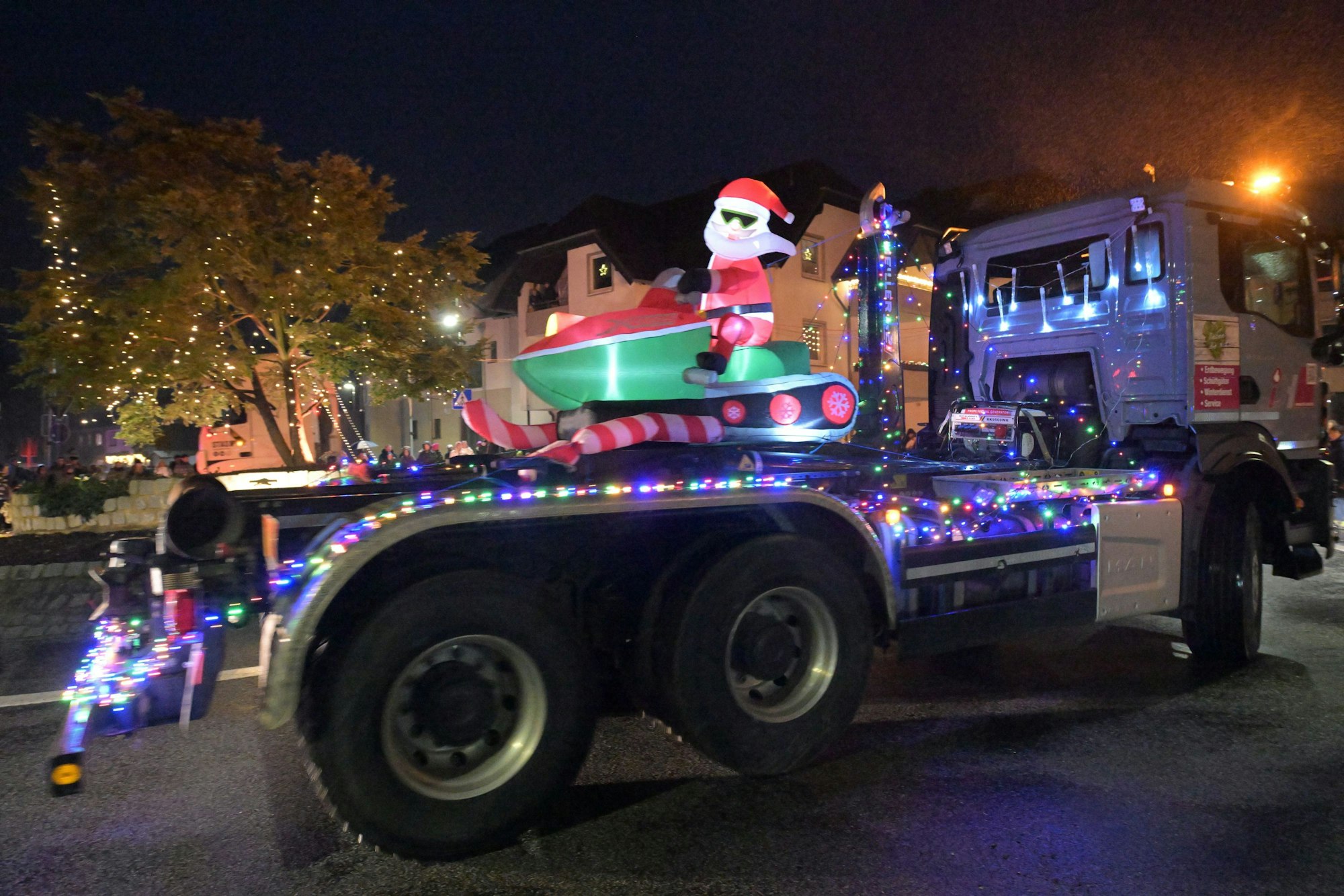 Ein Lastwagen mit Weihnachtsmann auf Schnee-Bob fährt durch den Kreisverkehr in Overath-Heiligenhaus.