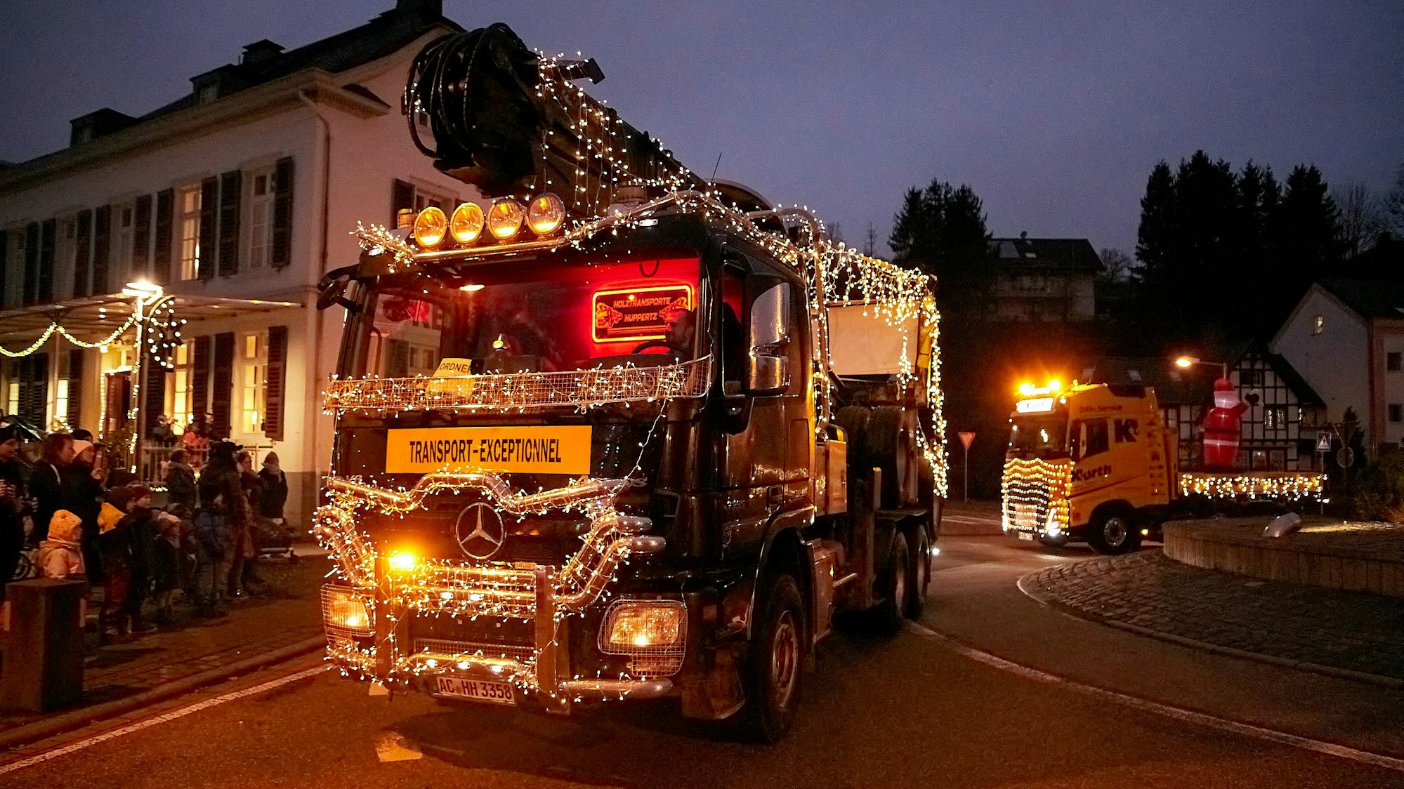 Das Bild zeigt zwei toll geschmückte Lkw während des Lichterzugs in der Eifel.