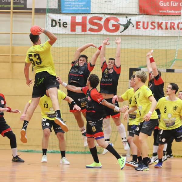 Zwei Palmersheimer Spieler springen hoch, um einen Torwurf abzuwehren.Rund um sie herum stehen Mitspieler und Gegner.