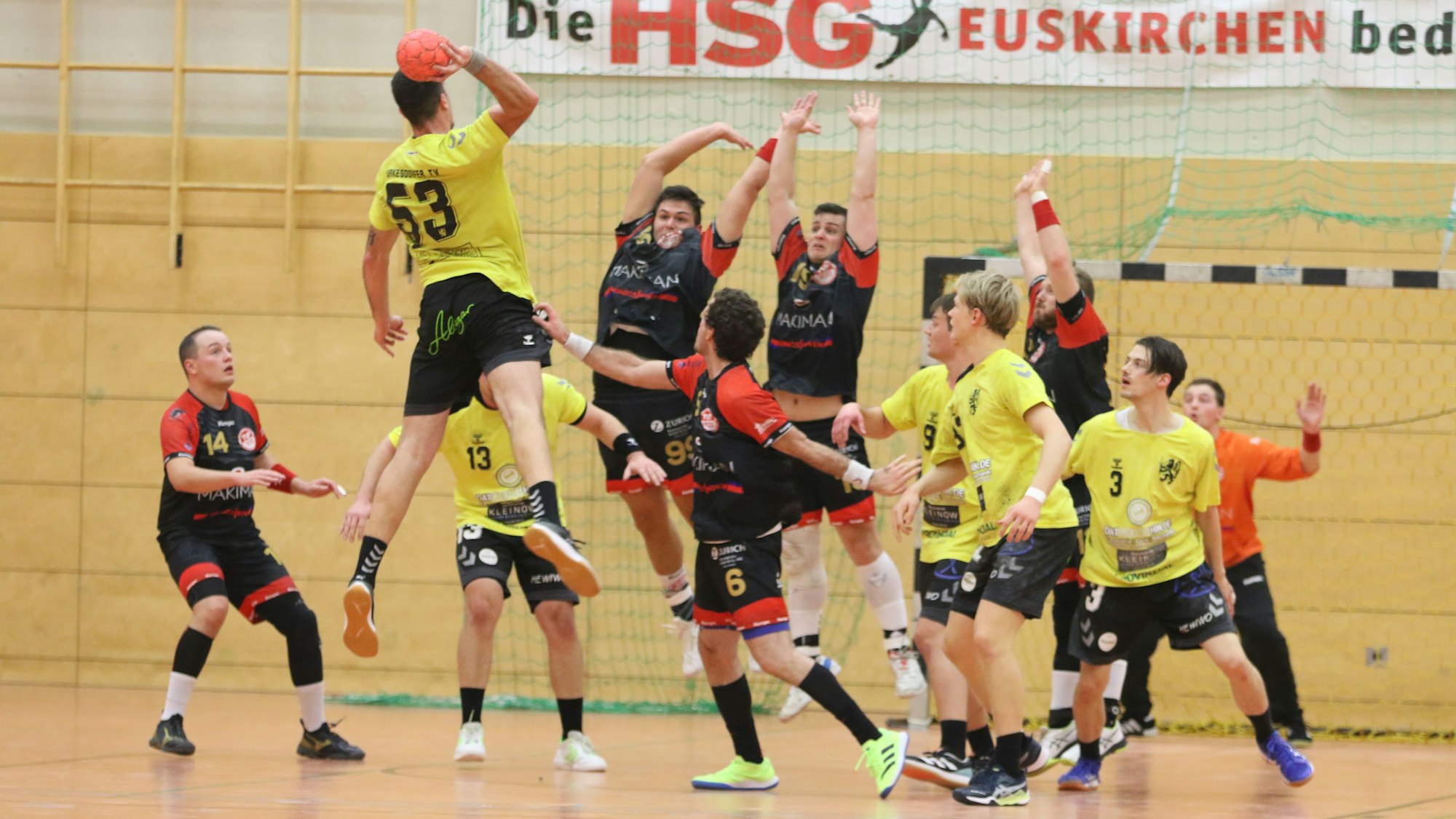 Zwei Palmersheimer Spieler springen hoch, um einen Torwurf abzuwehren.Rund um sie herum stehen Mitspieler und Gegner.