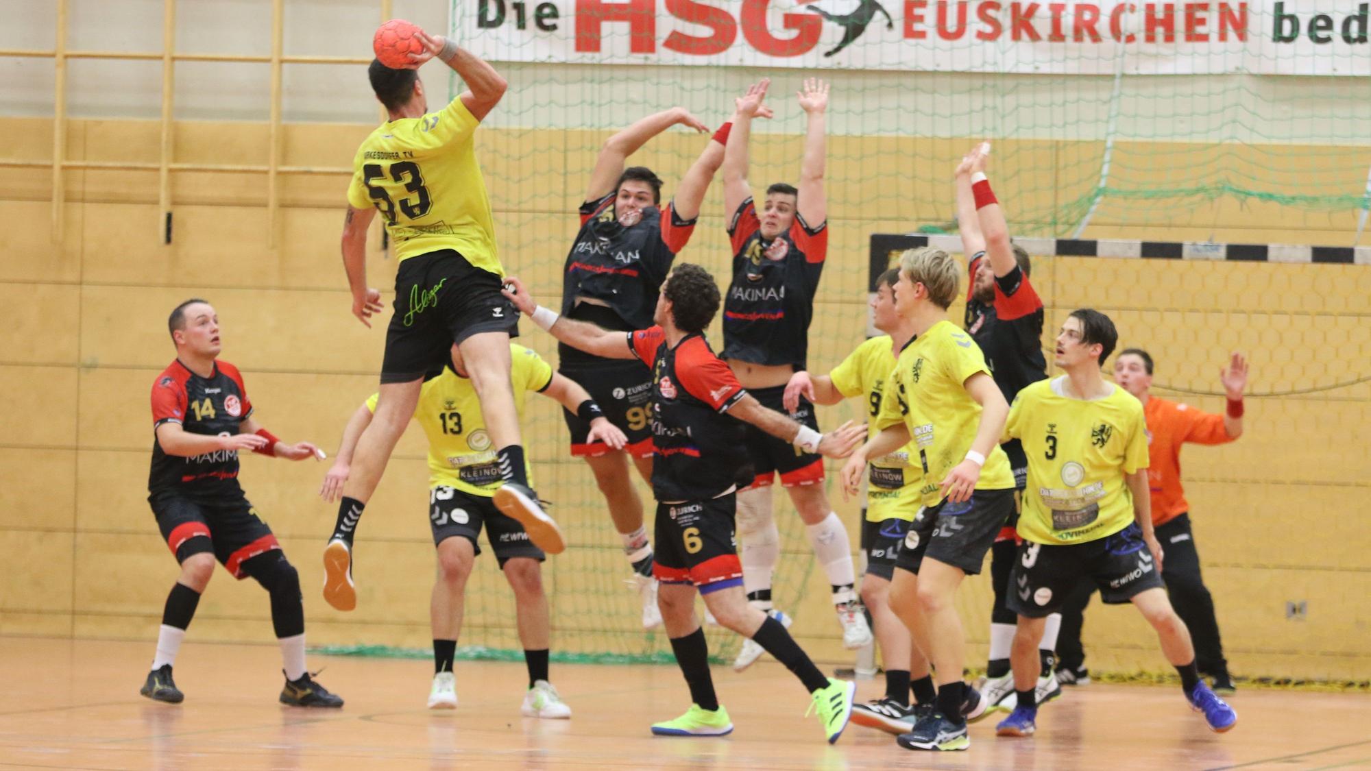 Das Bild zeigt einige Spieler des TV Palmersheim, die hochspringen, um einen Ball abzuwehren.