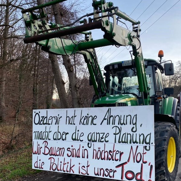 Ein Traktor aus einem Lichterzug trägt ein Plakat mit der Aufschrift „Özdemir hat keine Ahnung, macht aber die ganze Planung. Wir Bauern sind in höchster Not, die Politik ist unser Tod“.