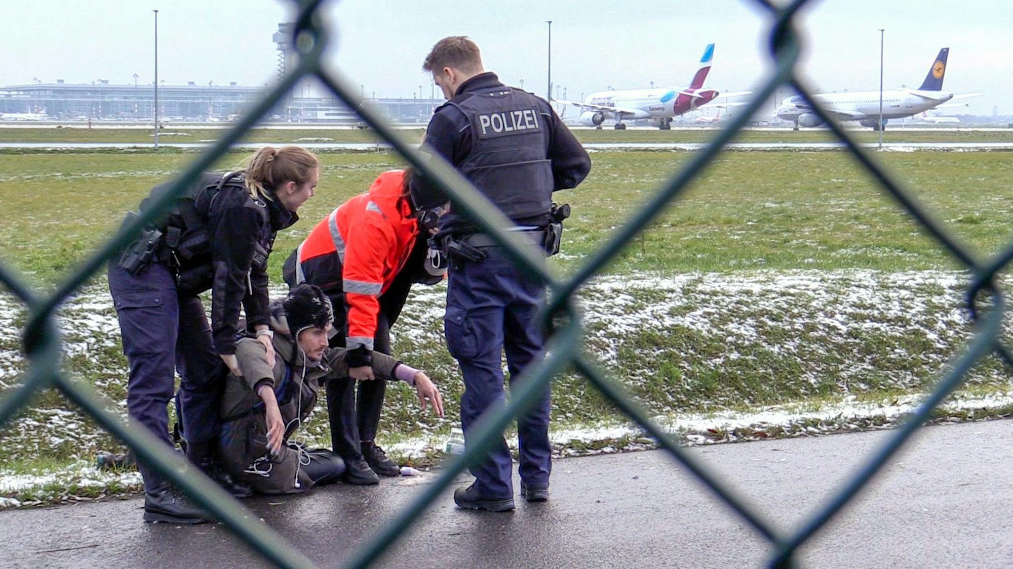 08.12.2022, Brandenburg, Schönefeld: Zwei Beamte der Bundespolizei und ein Sicherheitsmitarbeiter steht mit einem sichergestellten Bolzenschneider an einem Zaun am BER-Flughafen. Aktivisten der Umweltschutzgruppe "Letzte Generation" hatten versucht auf das Rollfeld zu gelangen. Foto: Paul Zinken/dpa +++ dpa-Bildfunk +++