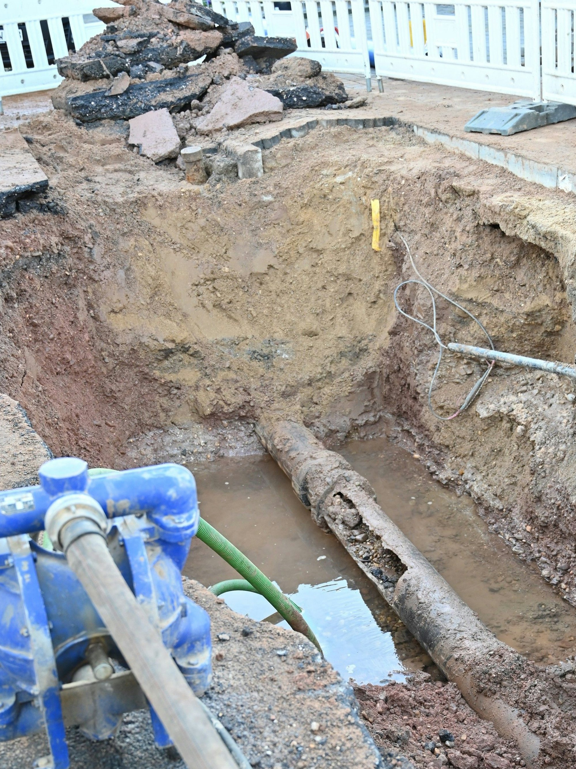 Das Bild zeigt eine Baugrube mit einer geplatzten Wasserleitung.