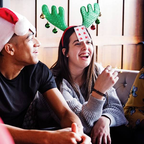 Eine Gruppe junger Leute spielt an Weihnachten ein Kartenspiel.