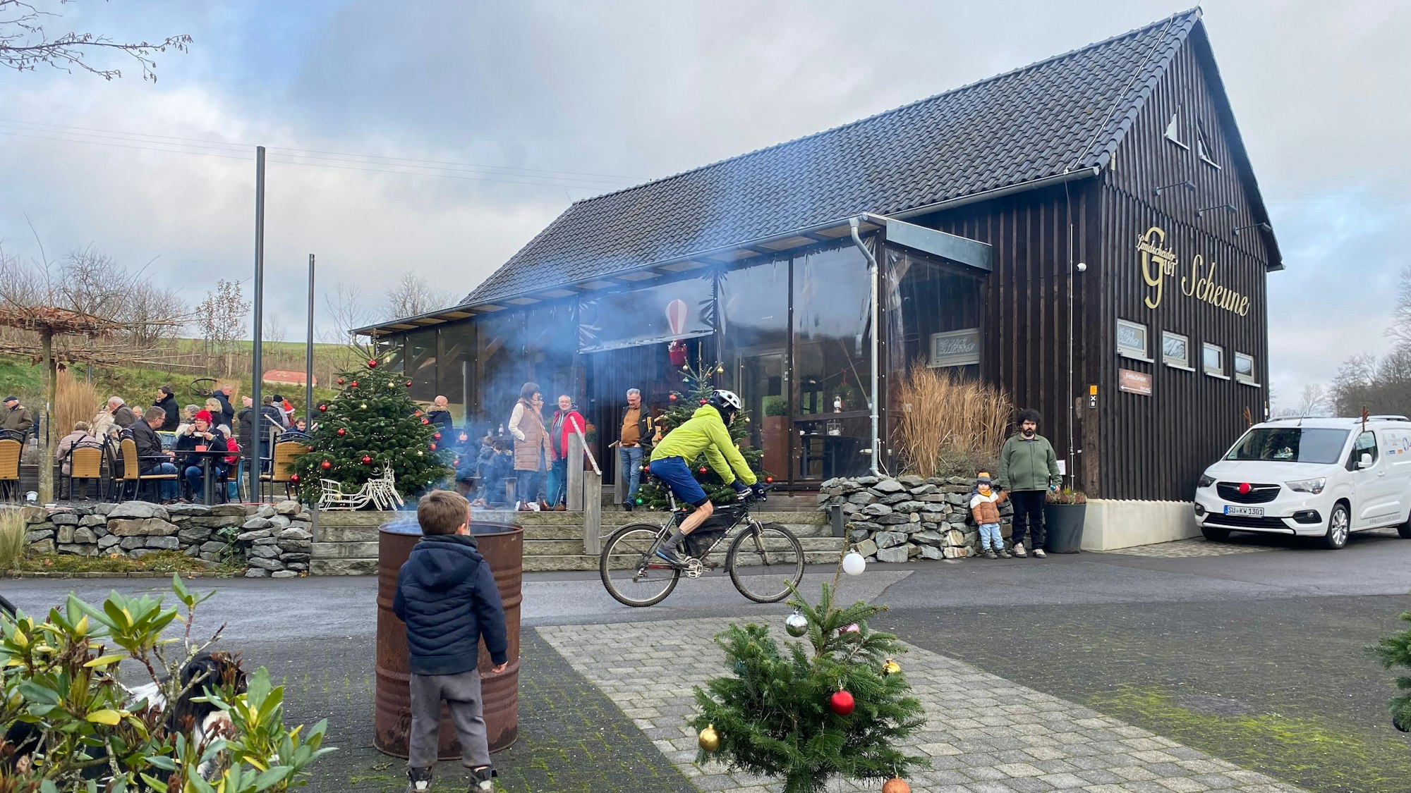 Menschen auf einem weihnachtlich geschmückten Hof.