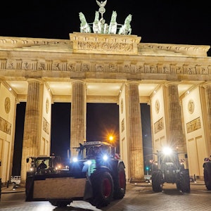 Landwirte aus Ostholstein stehen mit ihren Traktoren vor dem Brandenburger Tor.