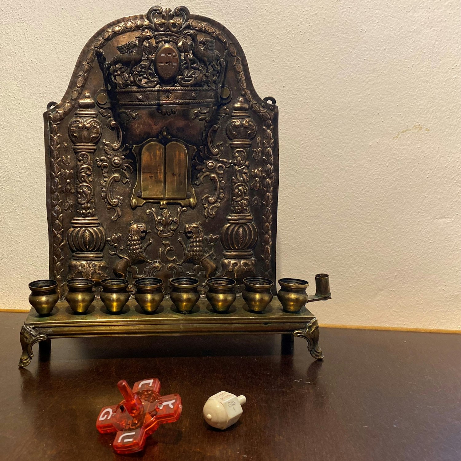 Auf dem Tisch steht ein Chanukkia. Davor liegen zwei Kreisel.