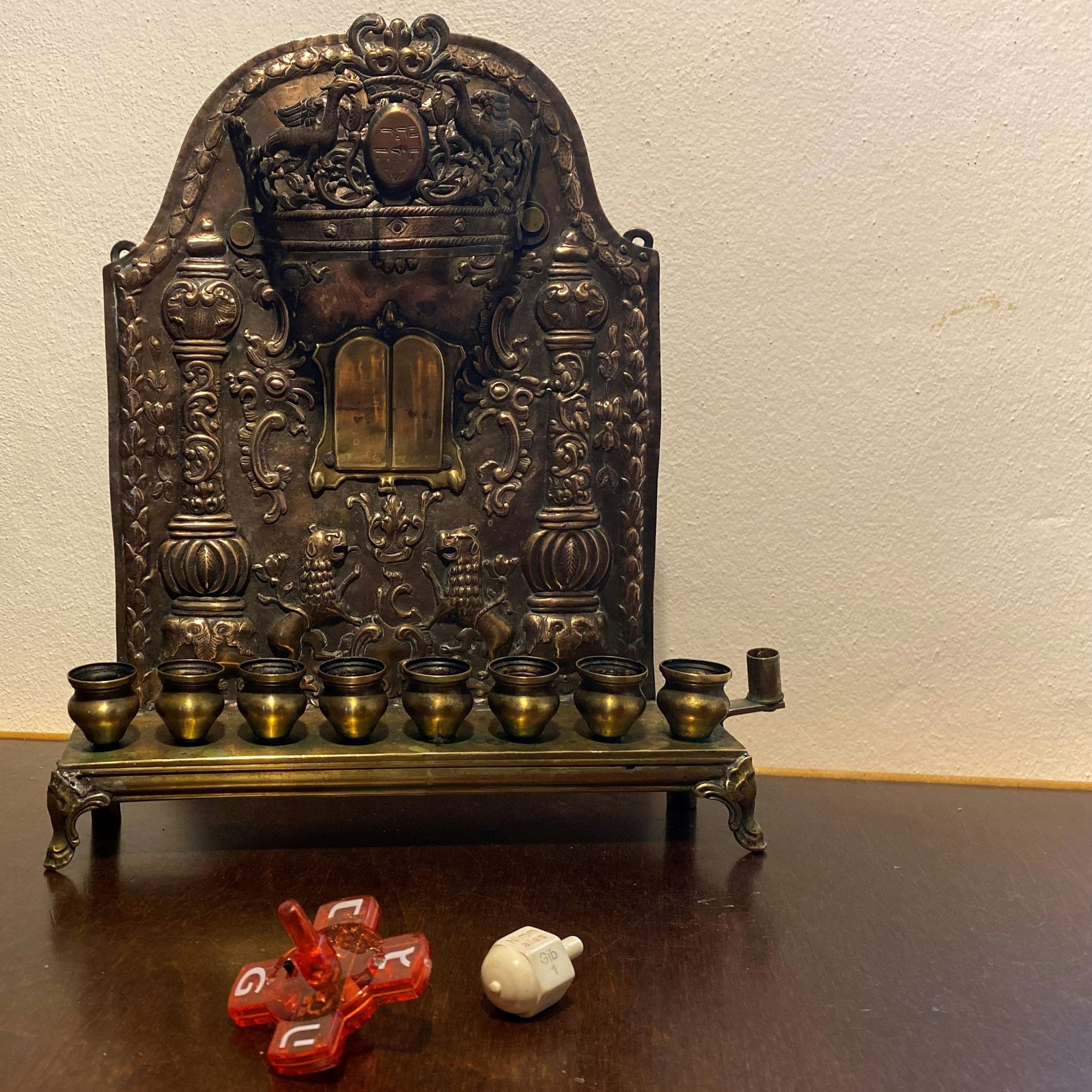 Auf dem Tisch steht ein Chanukkia. Davor liegen zwei Kreisel.