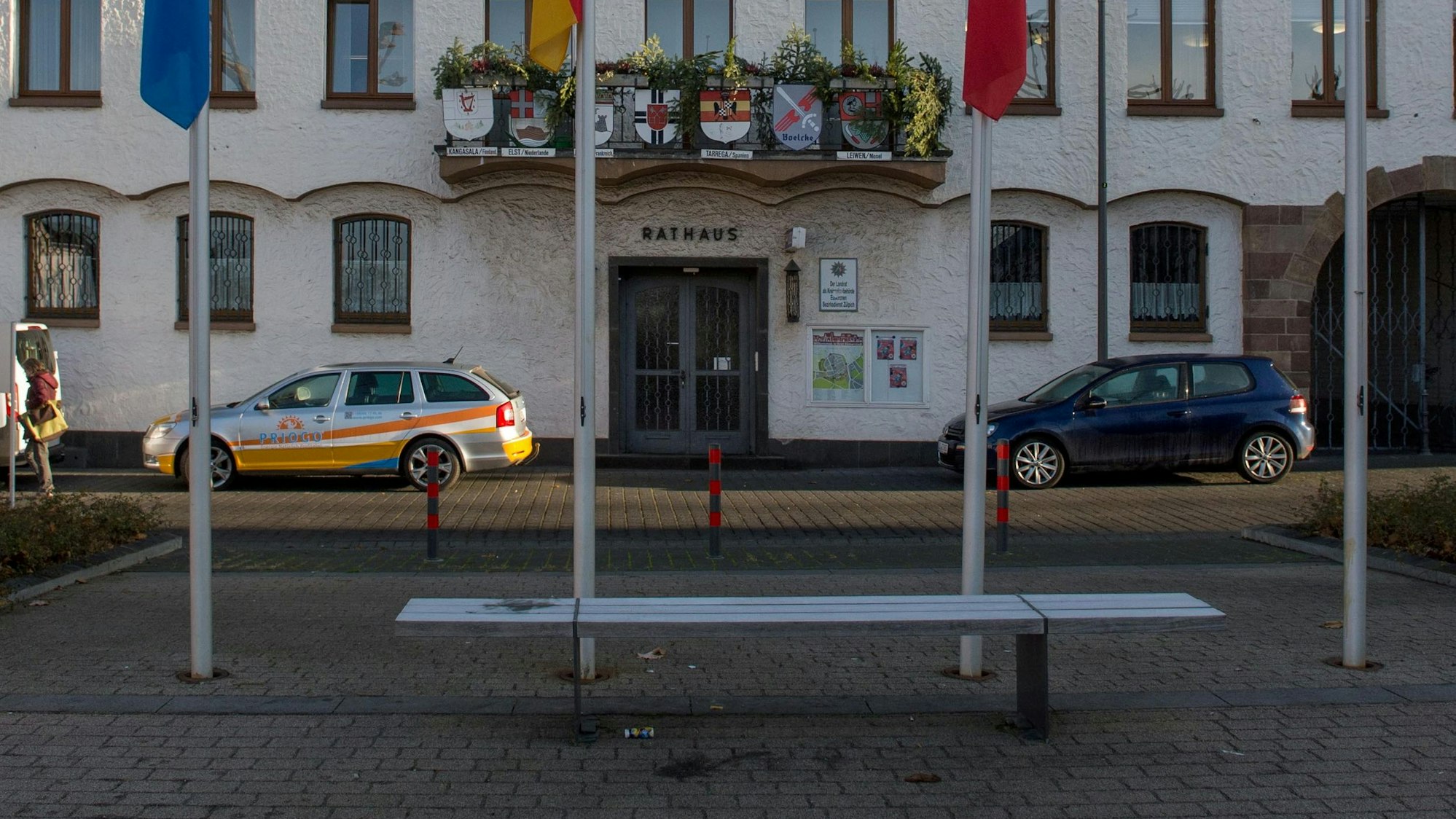 Autos parken in der Abendsonne vor dem Zülpicher Rathaus.