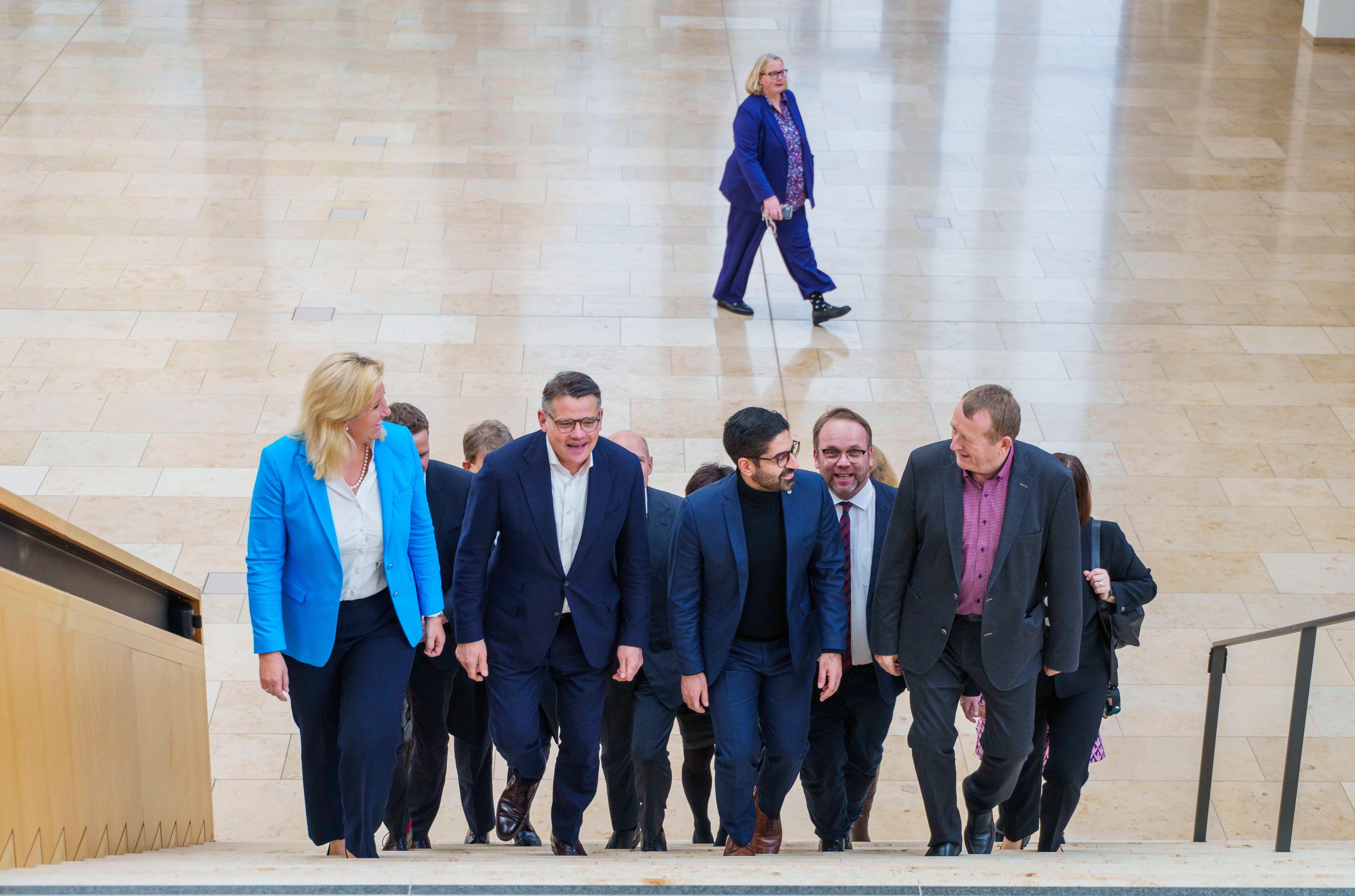 Die Verhandlungsgruppe mit Ines Claus (l-r, CDU), Fraktionsvorsitzende der CDU im Hessischen Landtag, Boris Rhein (CDU), Ministerpräsident von Hessen, Kaweh Mansoori (SPD), Vorsitzender der südhessischen SPD, und Günter Rudolph (SPD), Vorsitzende der SPD-Fraktion im Hessischen Landtag, an der Spitze gehen im RheinMain CongressCenter eine Treppe hoch.