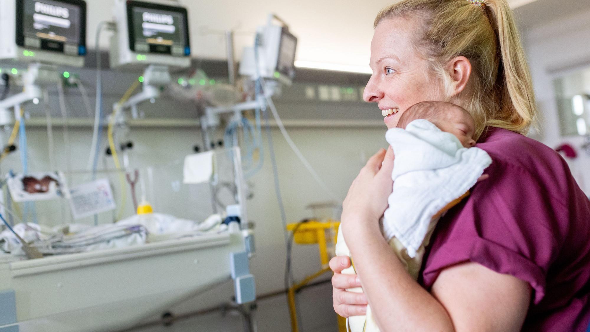 Kinderkrankenpflegerin Kathrin Kartal hält ein Frühchen auf dem Arm.