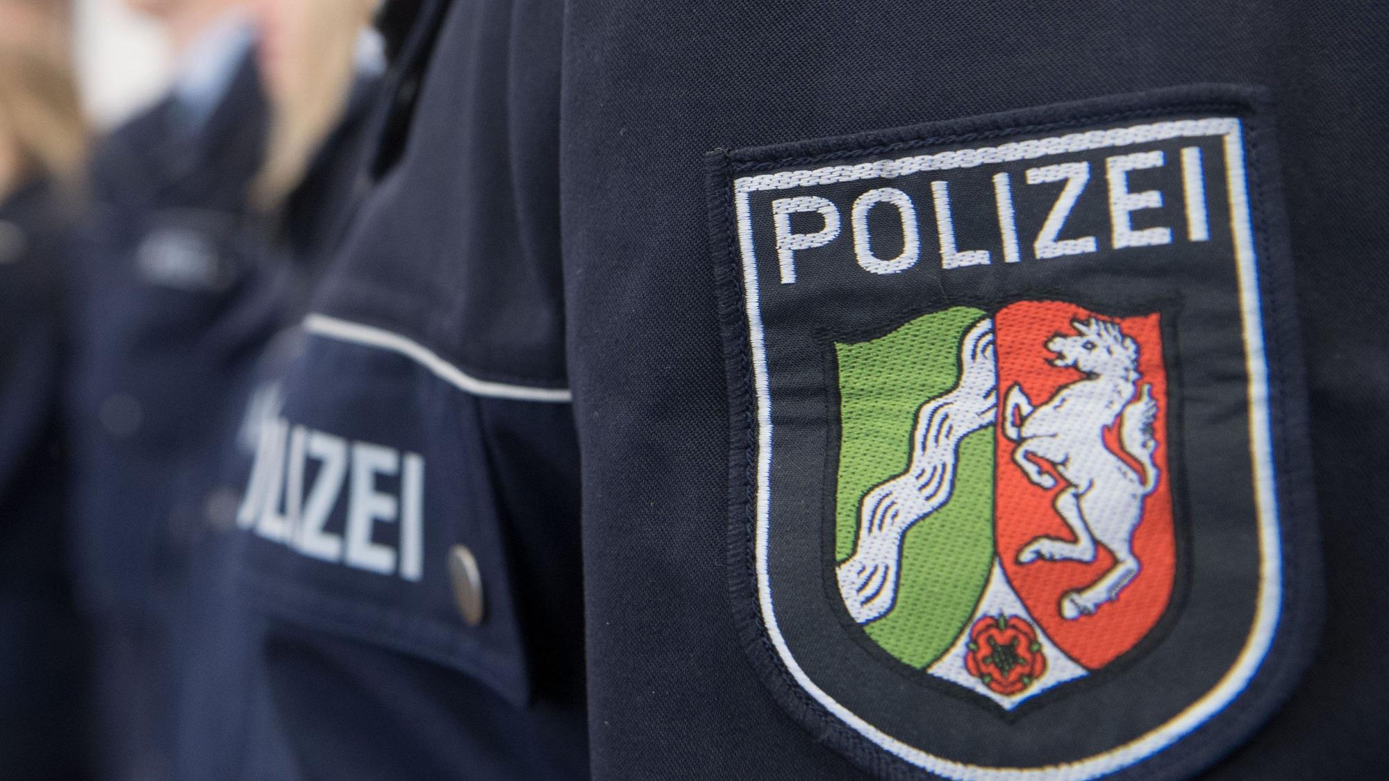 Auf einem Polizeihemd ist das Wappen von Nordrhein-Westfalen zu sehen.