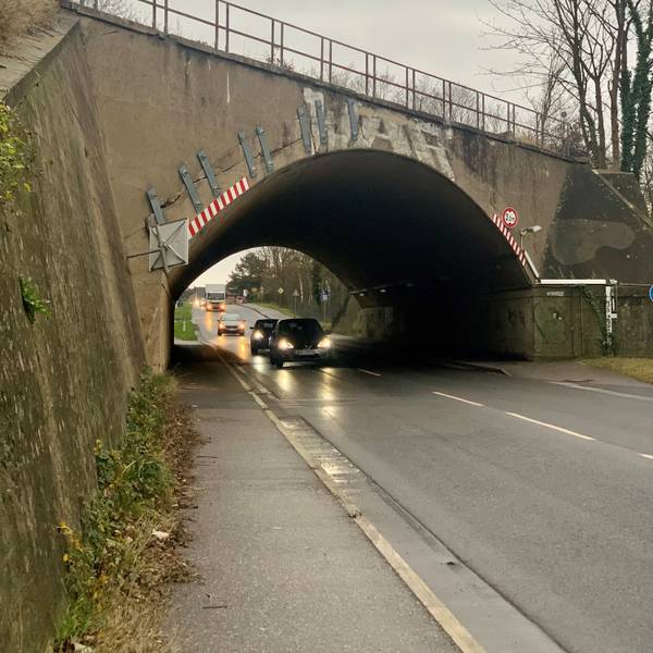 Unter einer Brücke fahren Autos hindurch.