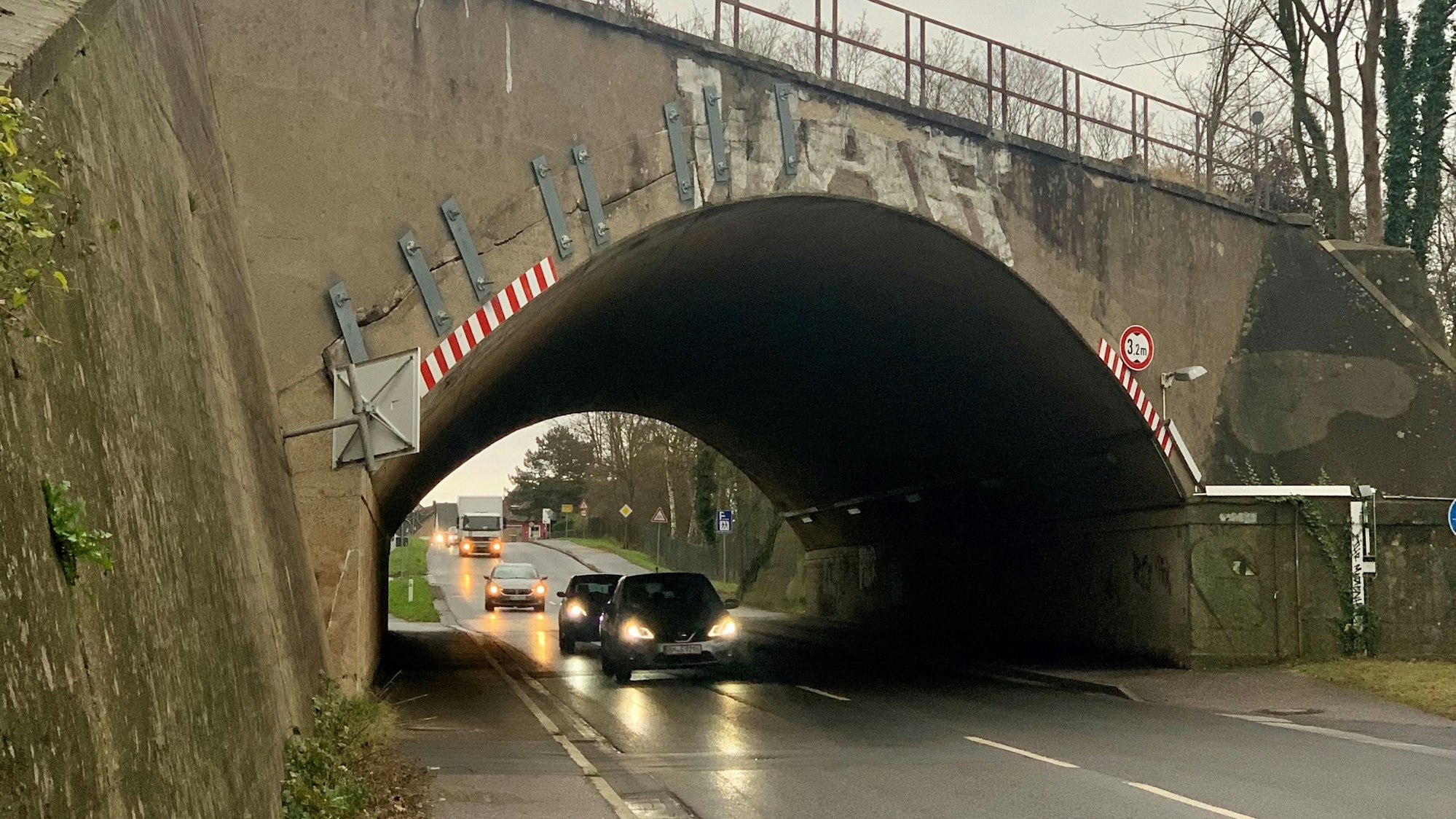 Unter einer Brücke fahren Autos hindurch.