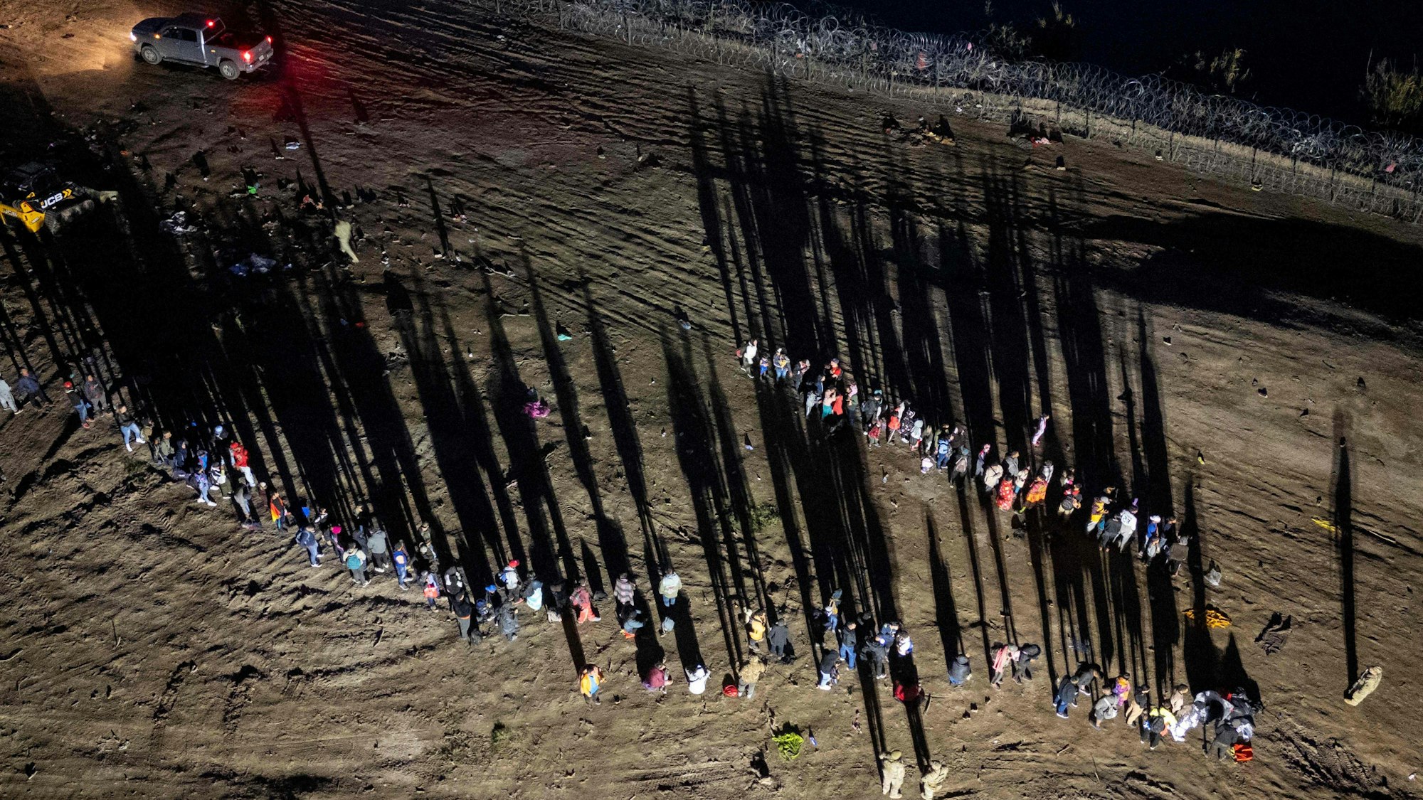 Migranten, die den Rio Grande von Mexiko aus überquert haben, stehen vor dem Aufnahmezentrum in Eagle Pass in Texas Schlange.