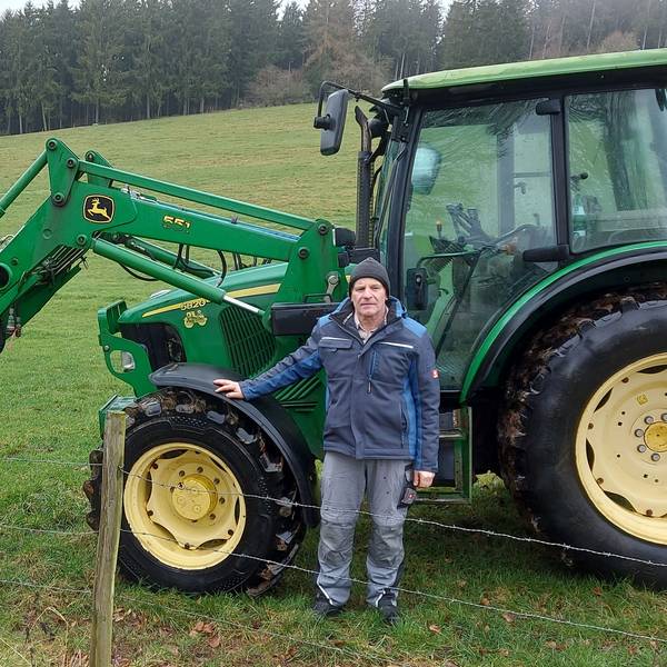 Der Baasemer Landwirt Johannes Nellessen steht neben einem seiner Traktoren auf einem Feld.