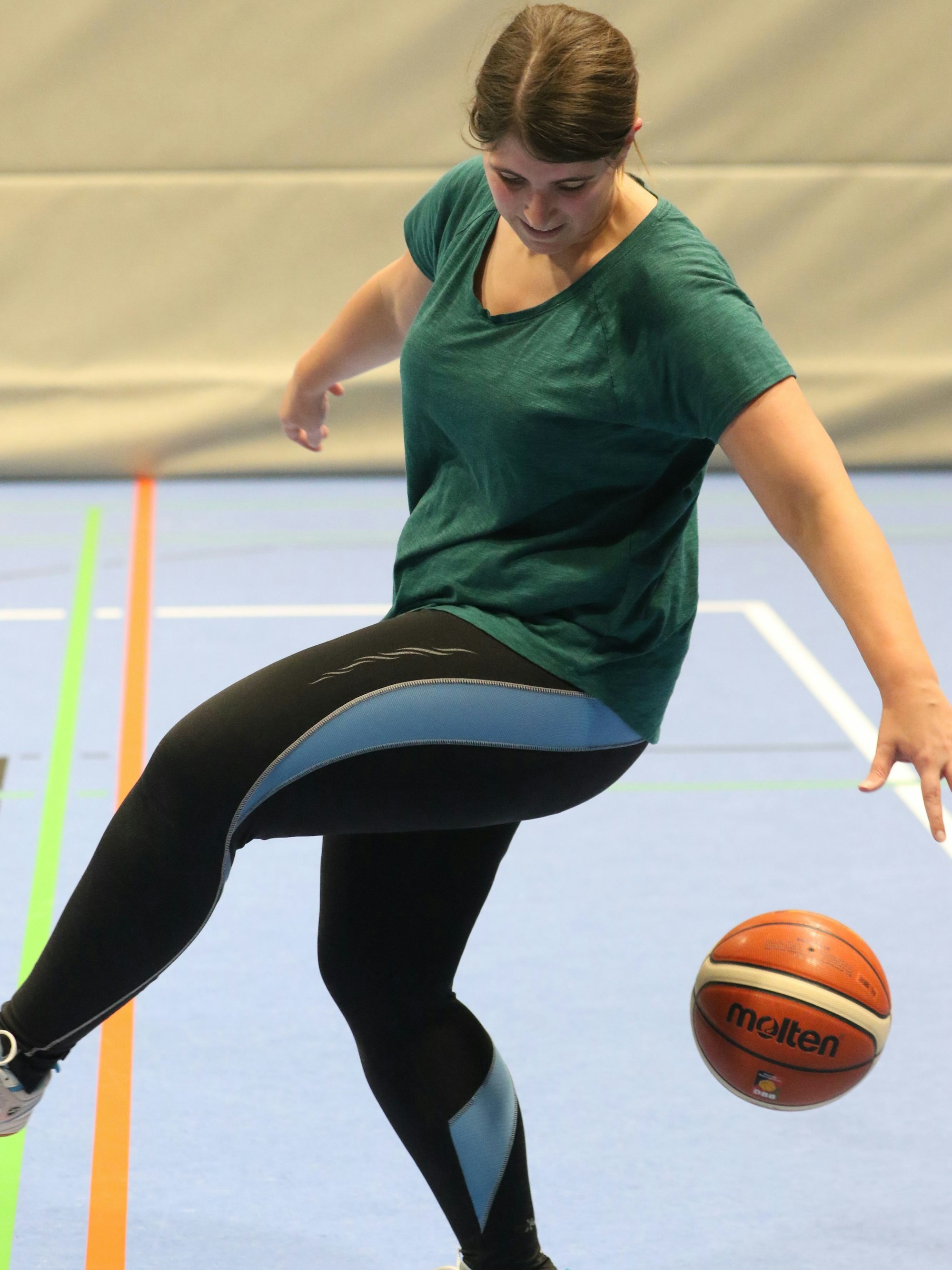 Juli Reuß versucht, einen Basketball hinter ihrem Körper zu dribbeln.