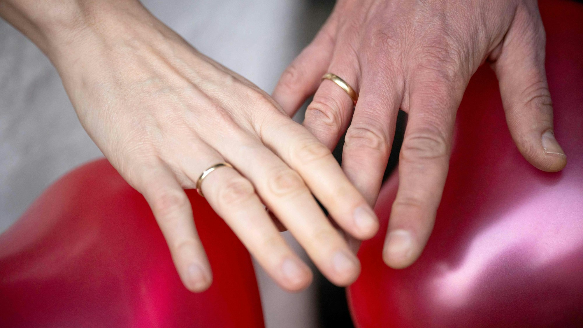 Ein frisch verheiratetes Paar präsentiert die Eheringe.