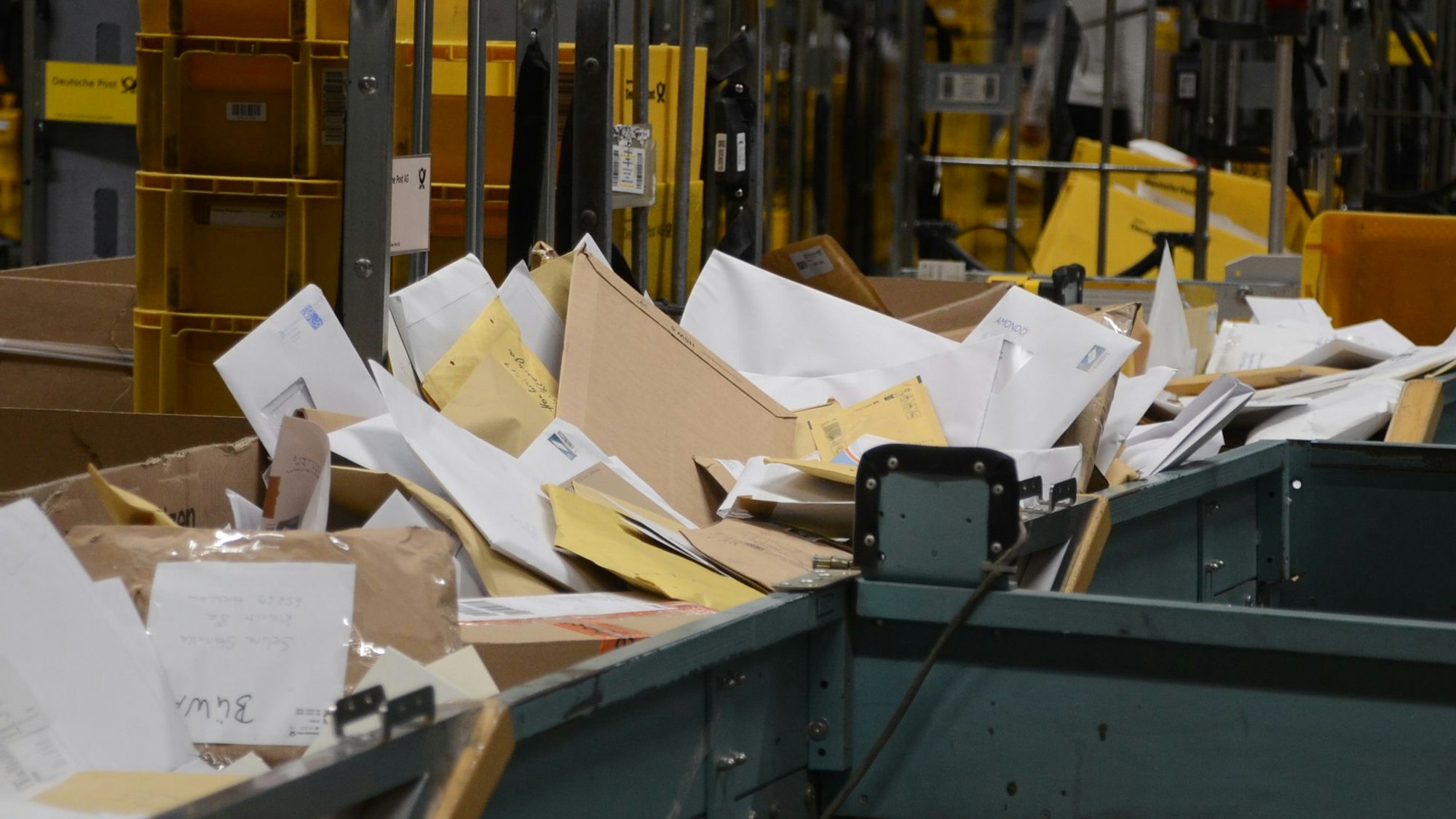 Große Mengen Post auf einem Förderband, das fast überquillt.