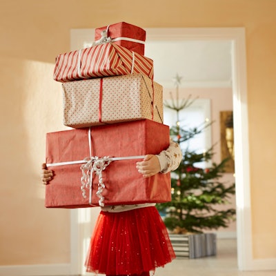 Mädchen hält einen Berg Geschenk im Arm