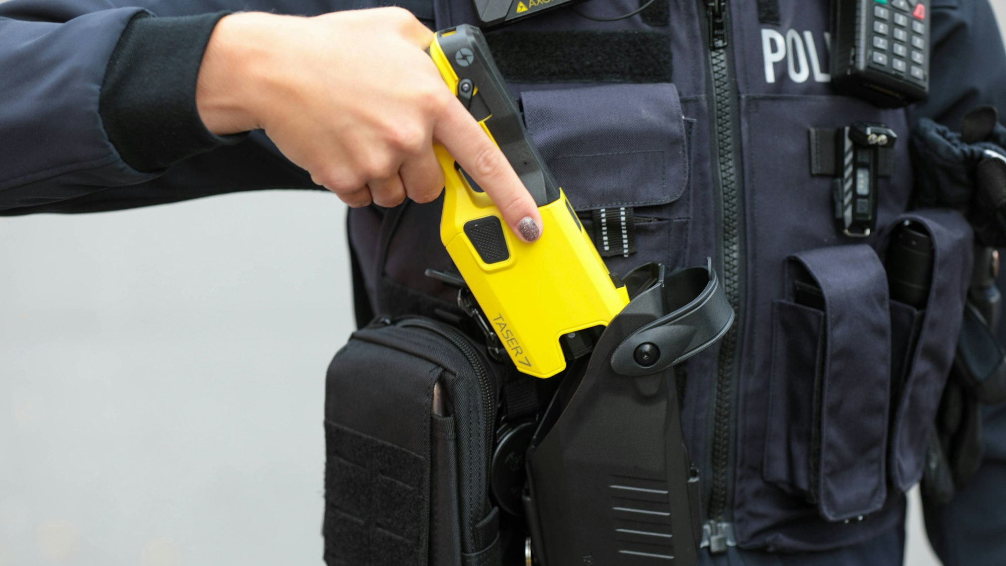 Ein Polizist zeigt Distanzelektroimpulsgeräte, besser bekannt als Taser, die in NRW flächendeckend als Ausrüstung eingeführt wurden. (Archivbild)