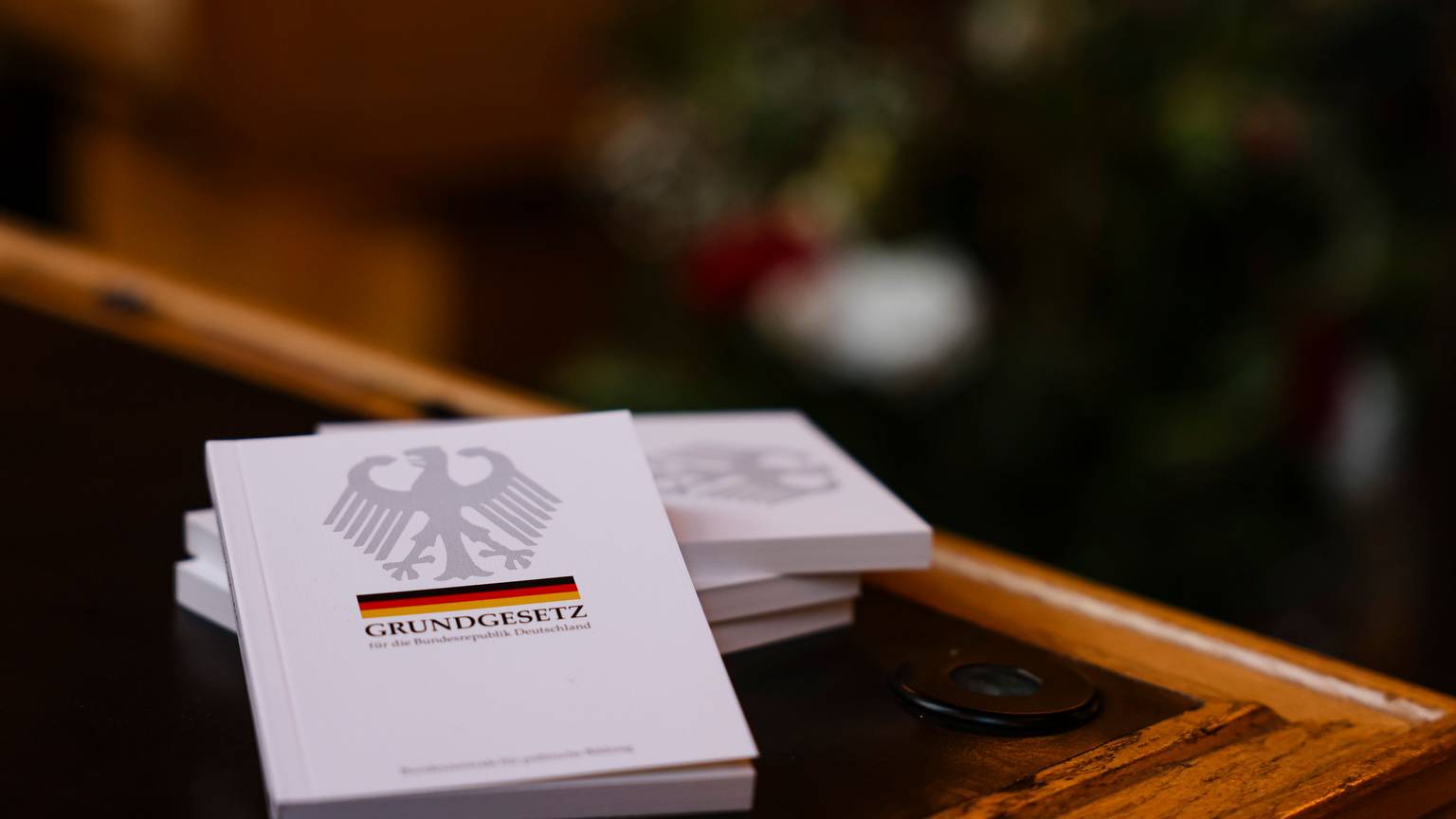 Vier Bücher mit dem Grundgesetz liegen auf einem Tisch.