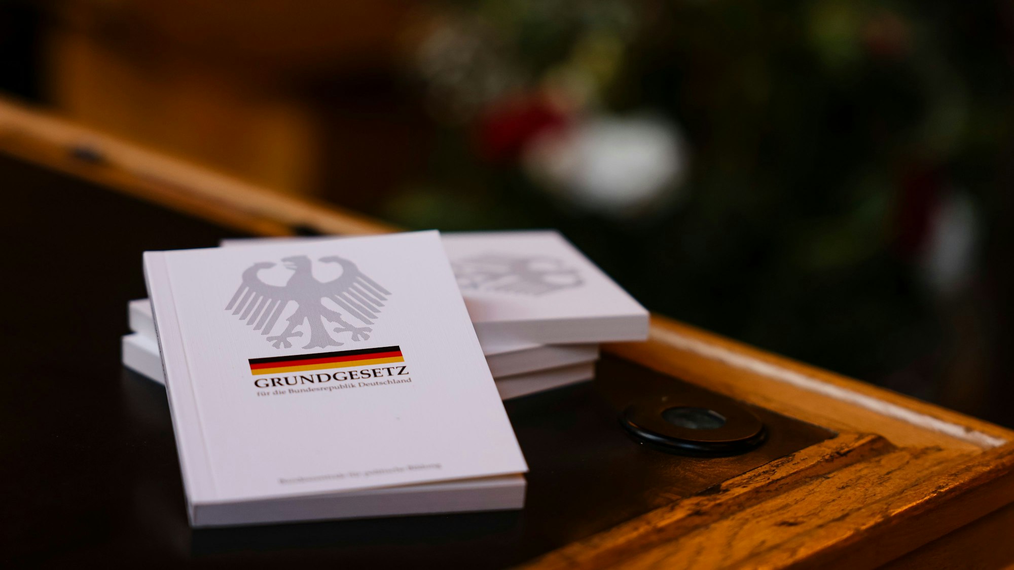Vier Bücher mit dem Grundgesetz liegen auf einem Tisch.