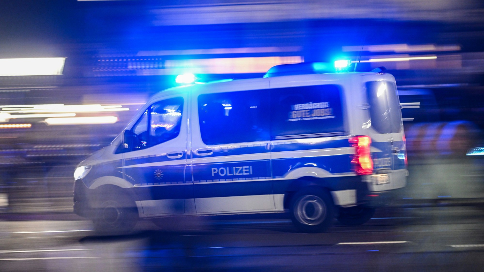 Ein Polizeiauto fährt mit Blaulicht.