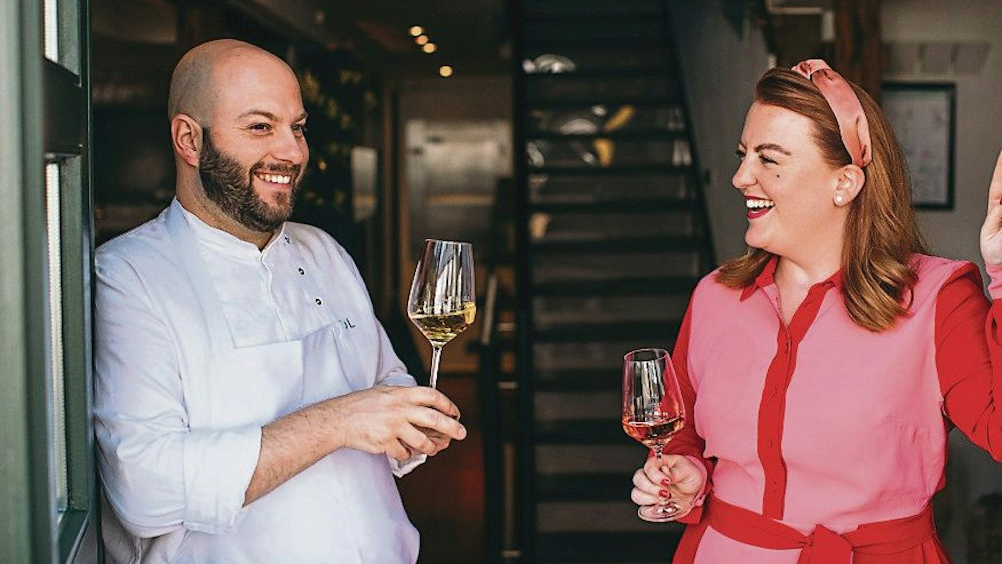 Daniel und Stephanie Lengsfeld mit Weingläsern in der Hand im Eingang ihres Gasthauses Scheiderhöhe.
