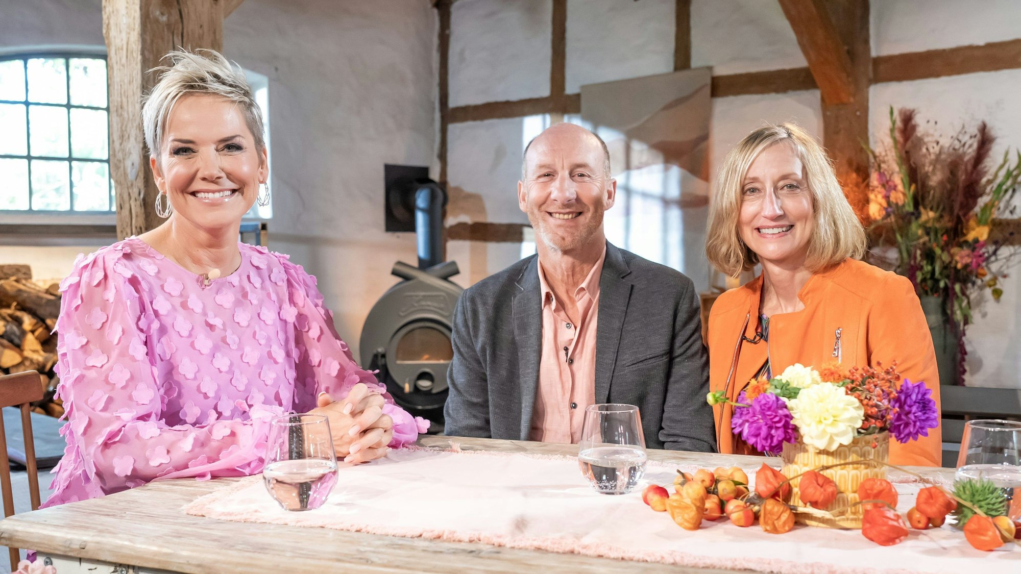 RTL-Moderatorin Inka Bause (l.) sitzt mit Hans und Elke an einem herbstlich dekorierten Tisch.