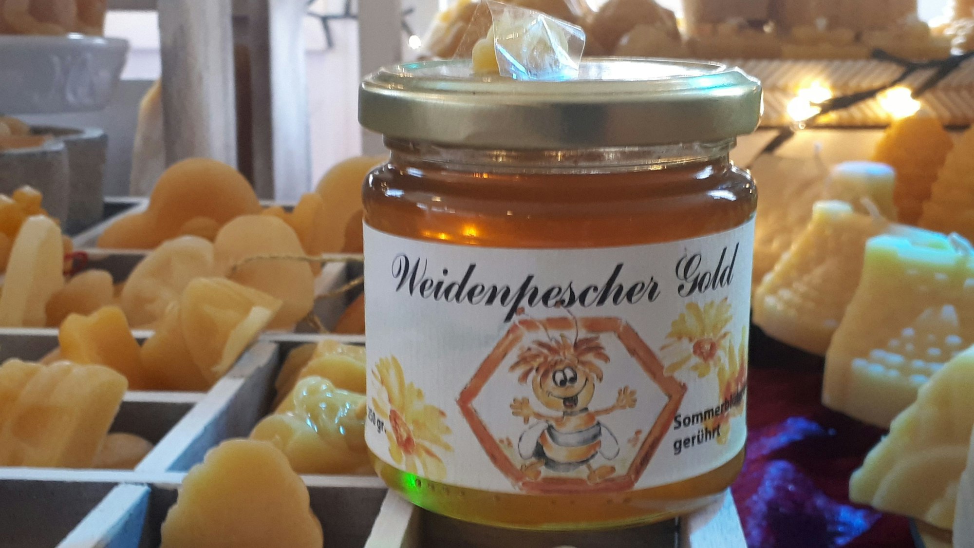 Honig aus dem Veedel und Bienenwachs-Kerzen in verschiedenen Formen im „Weidenpescher Gold“.