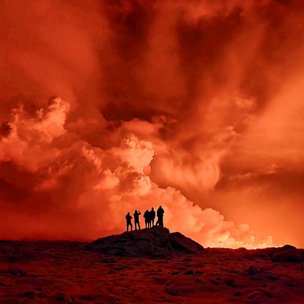 Vulkanausbruch auf Island: Drei Personen beobachten Magma, Lava und den orangem Himmel.