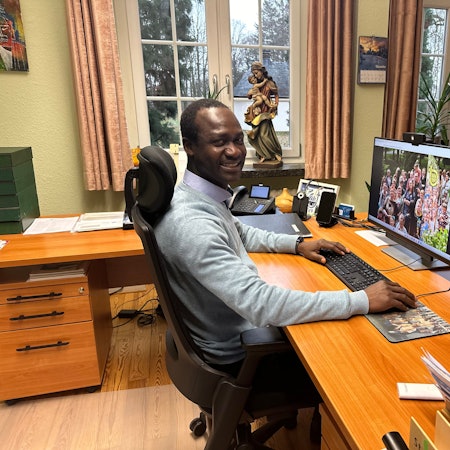 Pater Peter Claver Kwame Narh aus Ghana an seinem Schreibtisch im Kloster. Auf der Fensterbank steht eine Marienstatue. Er hat seit Januar 2023 als Provinzial die Leitung der Steyler Missionare in Deutschland.