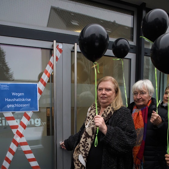 Drei Frauen stehen an einer Tür.